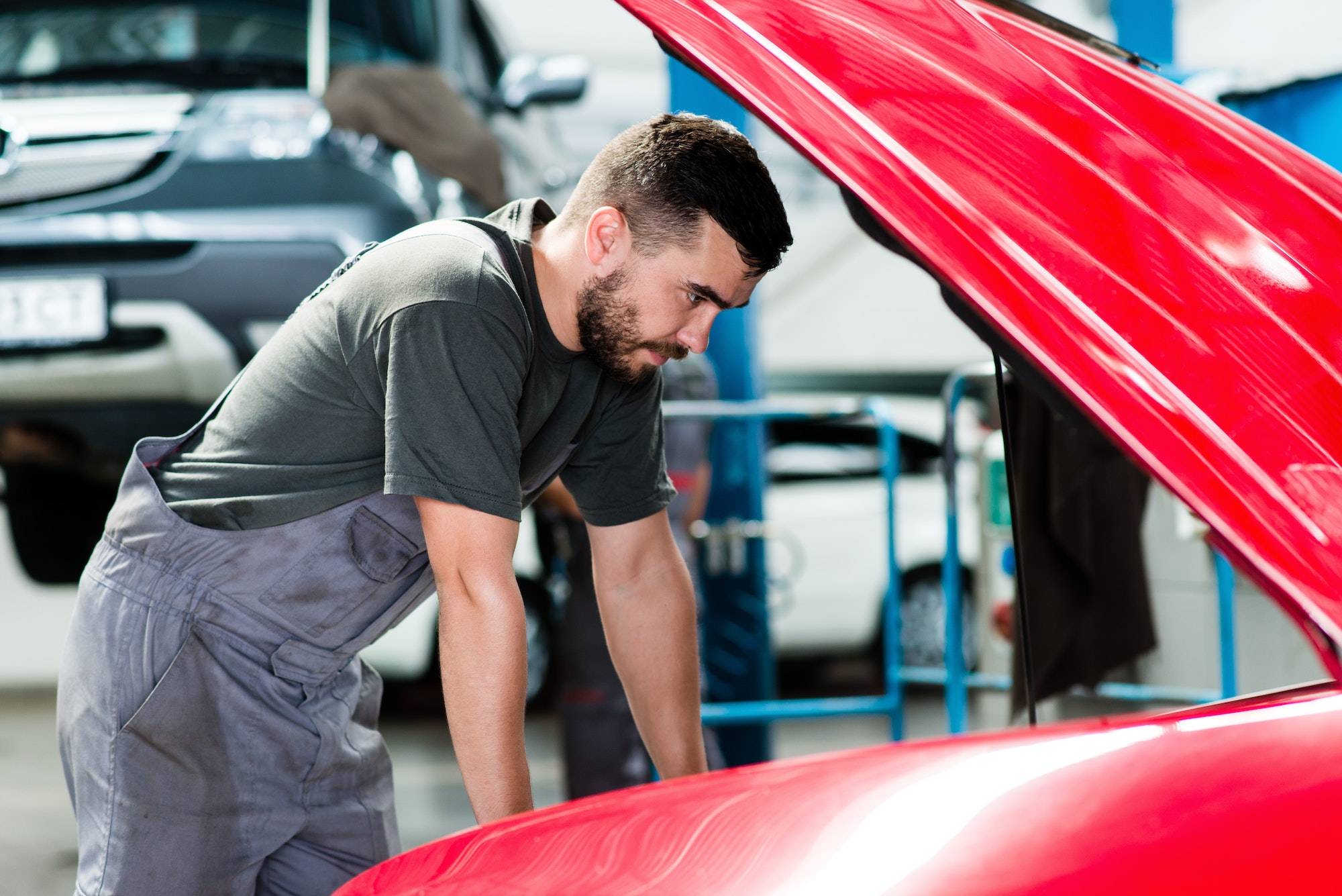 auto-mechanic-working-in-garage-repair-service-looking-at-the-car-s-motor-image.jpg